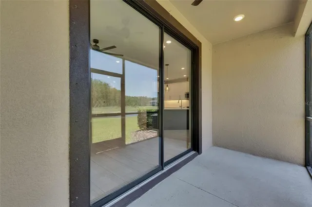an aerial view of a house with outdoor space and trees all around
