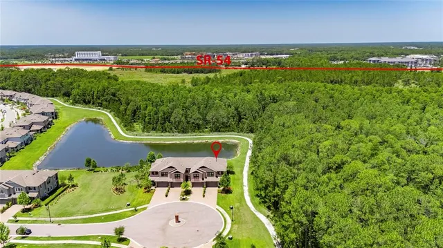 a view of sign board with buildings in background