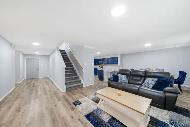 a living room with furniture and a wooden floor