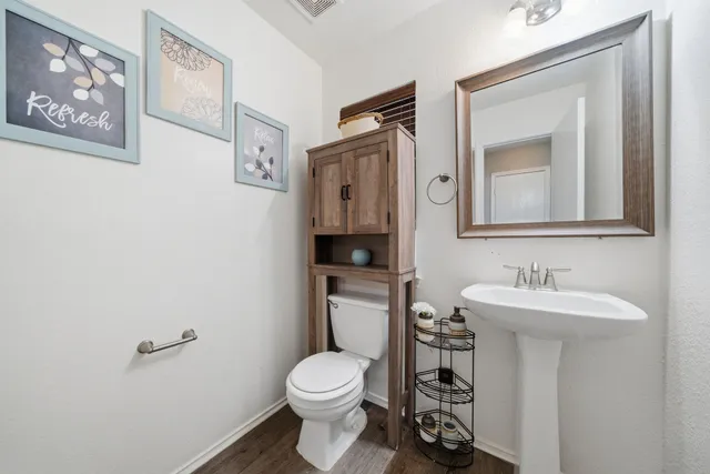 a bathroom with a toilet sink and mirror