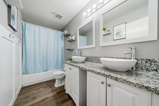 a bathroom with a granite countertop sink toilet and shower