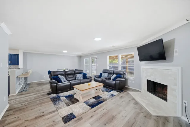 a living room with furniture a flat screen tv and a fireplace
