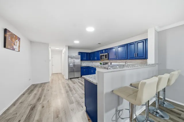 a kitchen with a table chairs refrigerator and wooden cabinets