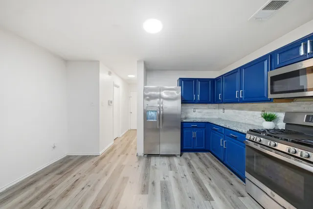 a kitchen with stainless steel appliances granite countertop a stove cabinets and wooden floor