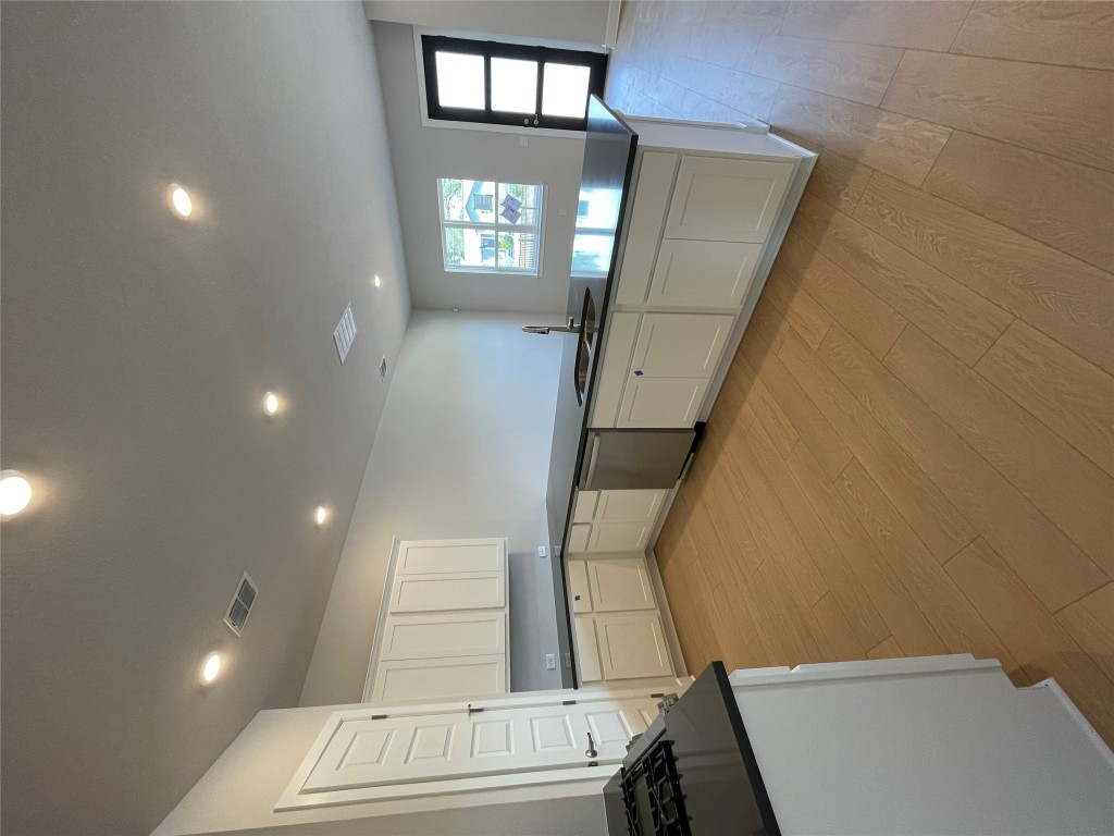 a large kitchen with stainless steel appliances granite countertop a lot of counter space and wooden floors