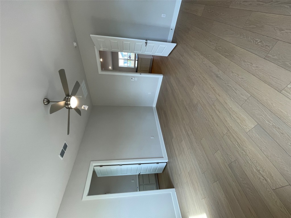 4701 Wally Avenue, Unit A Austin, TX 78721 - Photo 13 of 35 an empty room with wooden floor and windows