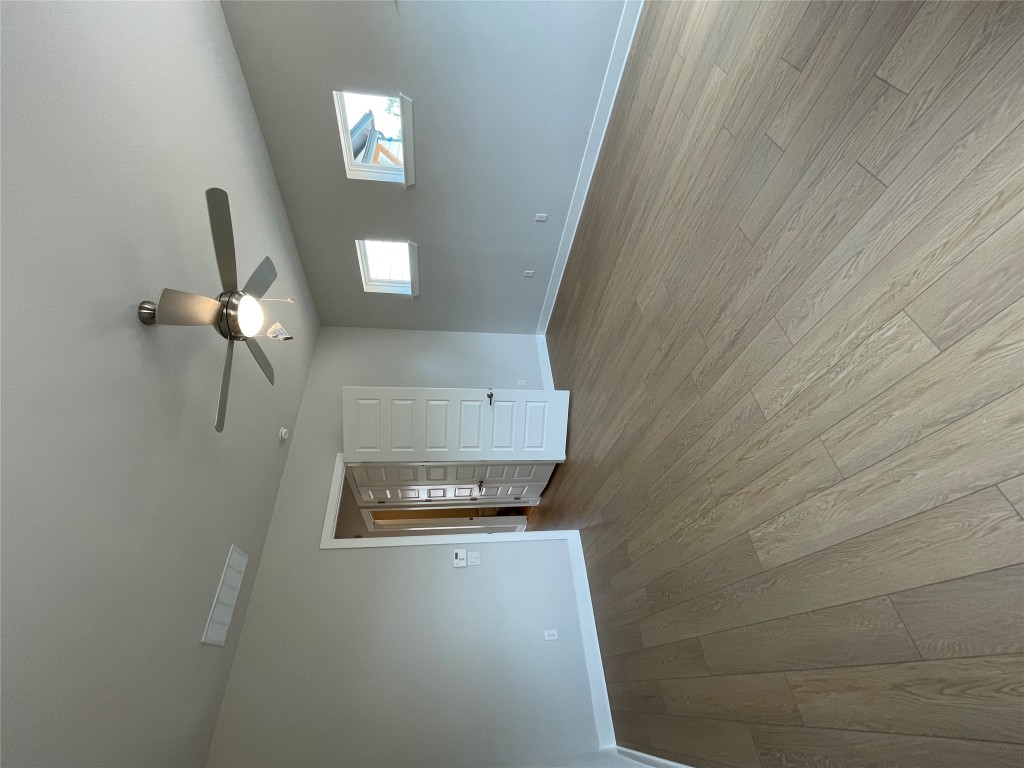 4701 Wally Avenue, Unit A Austin, TX 78721 - Photo 14 of 35 an empty room with wooden floor ceiling fan and windows