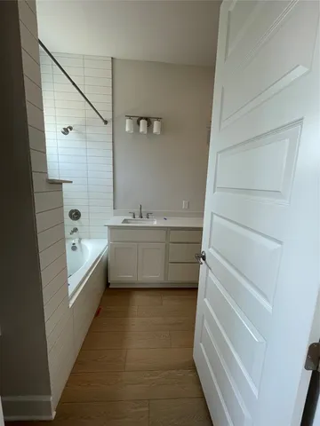 a bathroom with a tub a sink and a mirror