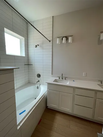 a bathroom with a tub sink and mirror