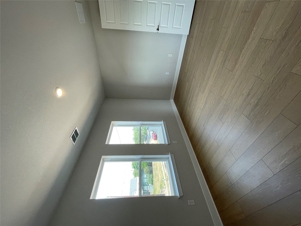 4701 Wally Avenue, Unit A Austin, TX 78721 - Photo 25 of 35 an empty room with wooden floor and windows