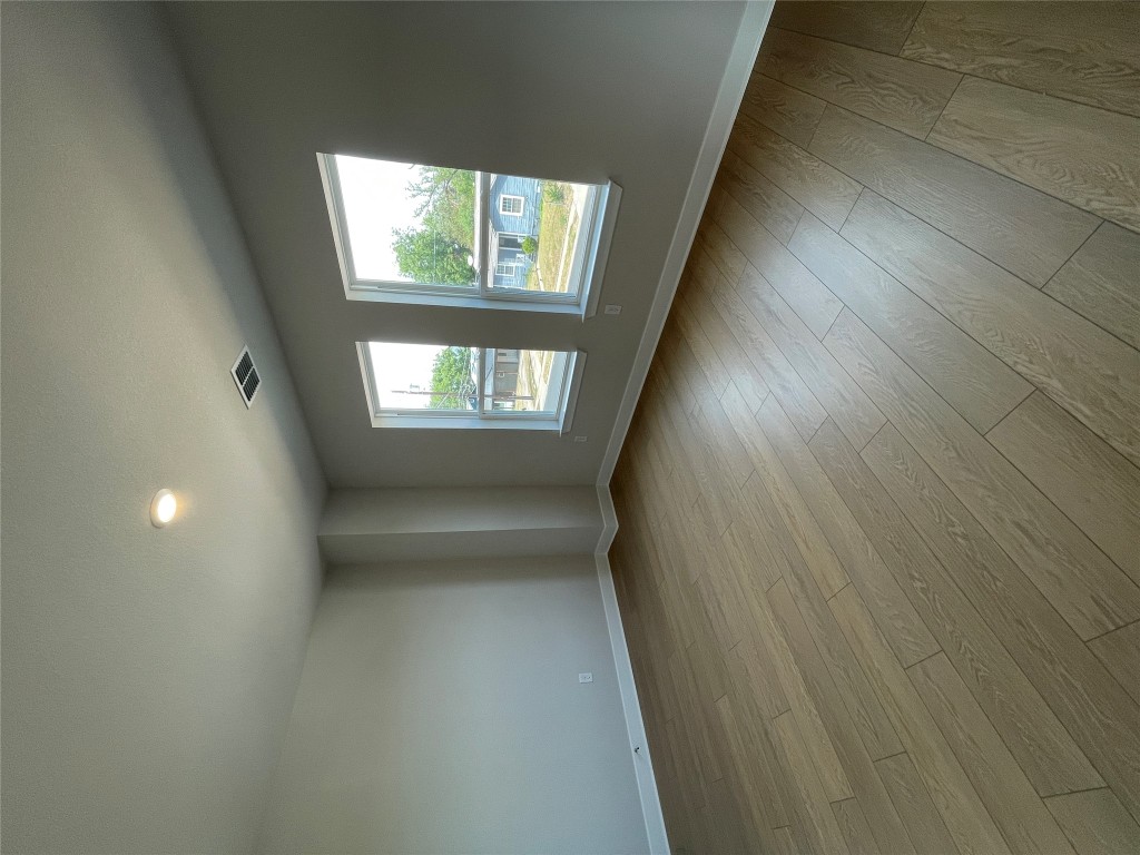 4701 Wally Avenue, Unit A Austin, TX 78721 - Photo 26 of 35 an empty room with wooden floor and windows