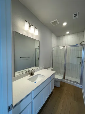 a bathroom with a double vanity sink toilet and shower