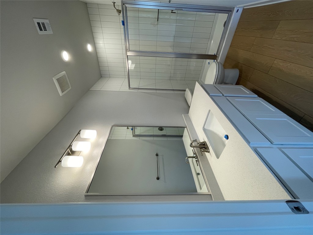 4701 Wally Avenue, Unit A Austin, TX 78721 - Photo 28 of 35 a bathroom with a double vanity sink toilet and shower