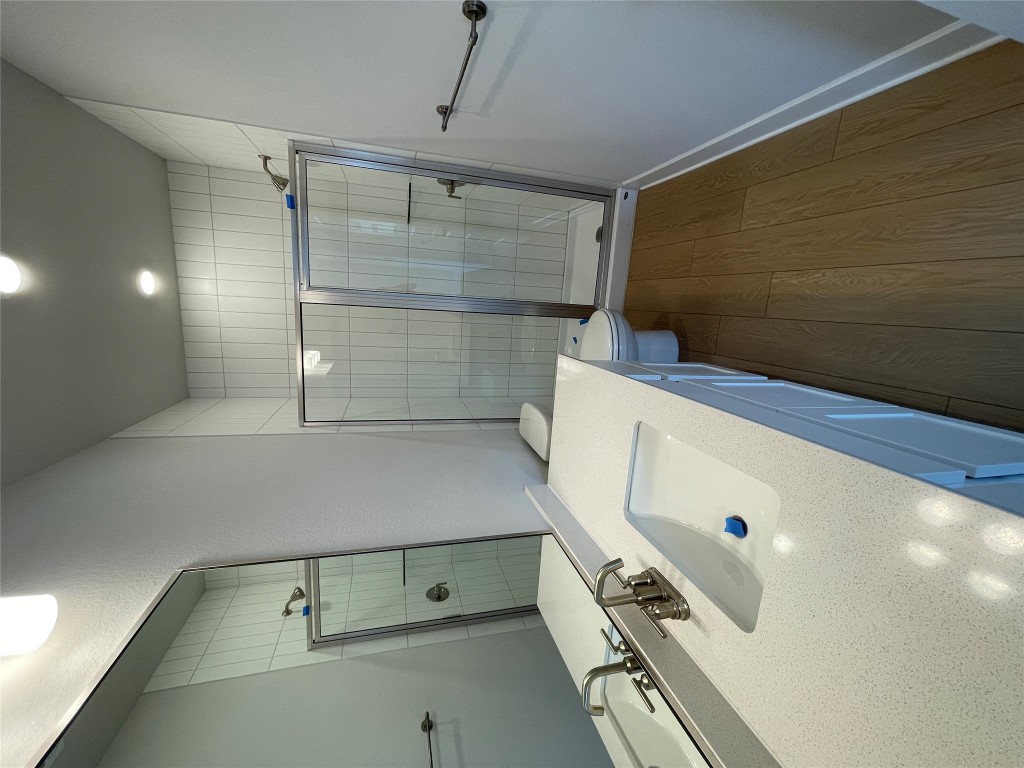 4701 Wally Avenue, Unit A Austin, TX 78721 - Photo 29 of 35 a bathroom with a sink a glass door shower and a sink