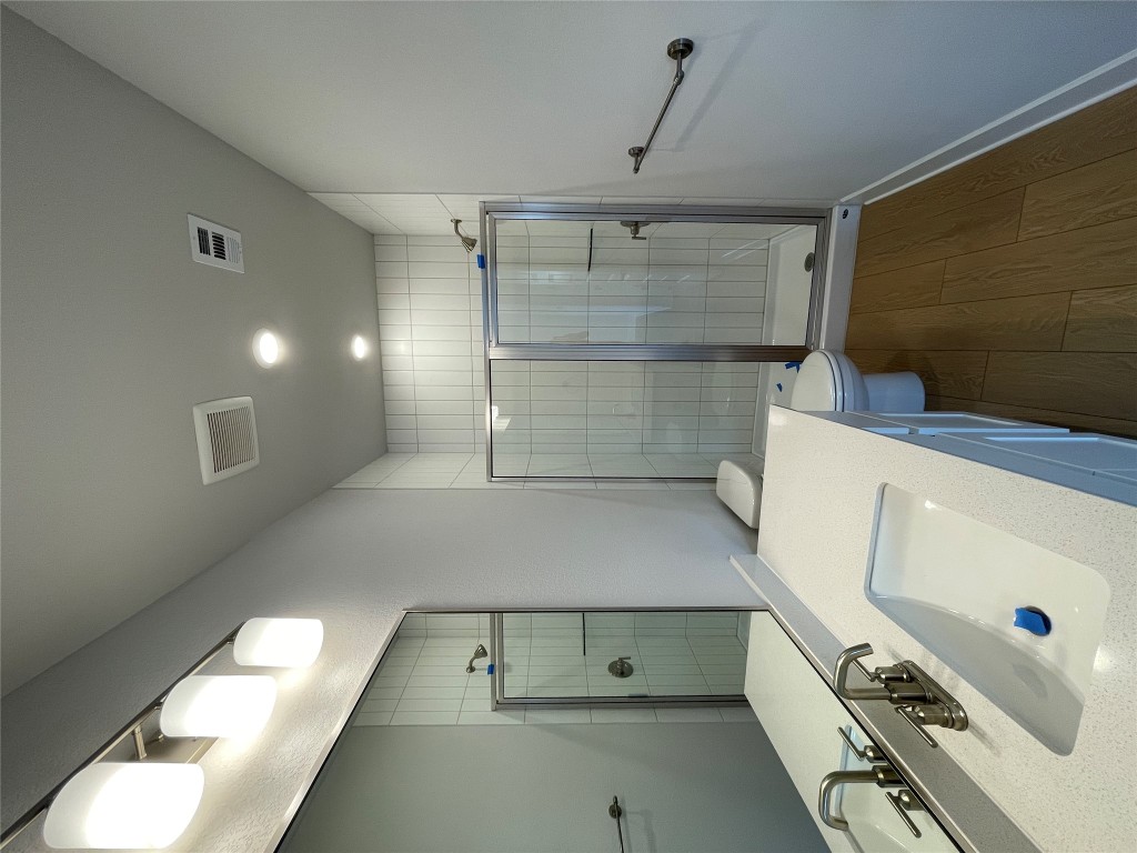 4701 Wally Avenue, Unit A Austin, TX 78721 - Photo 30 of 35 a bathroom with a sink a mirror and a bathtub