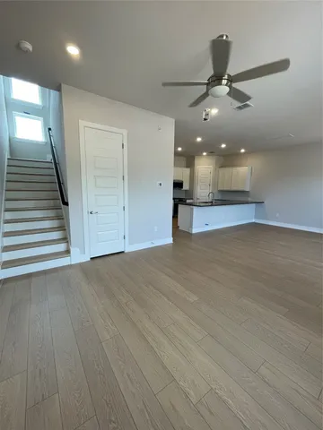 an empty room with wooden floor hallway and entryway