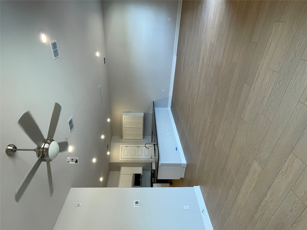 4701 Wally Avenue, Unit A Austin, TX 78721 - Photo 4 of 35 an empty room with wooden floor a ceiling fan kitchen view and a ceiling fan