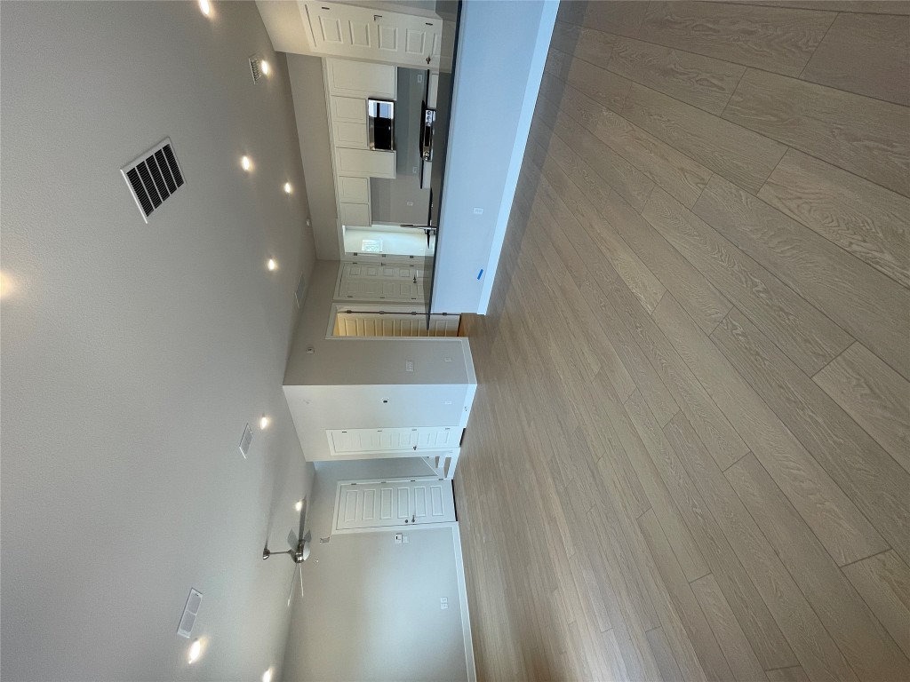 4701 Wally Avenue, Unit A Austin, TX 78721 - Photo 6 of 35 an empty room with wooden floor and windows