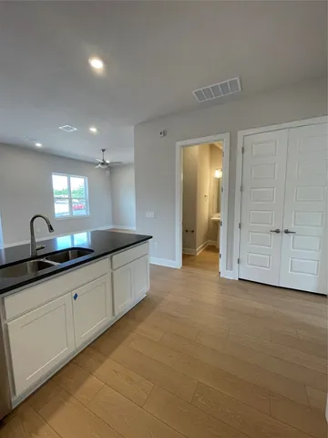 a large kitchen with granite countertop a sink and cabinets