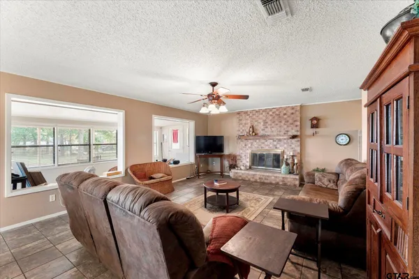 a living room with fireplace furniture and a large window