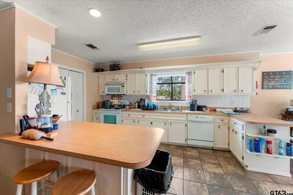 a kitchen with a table chairs sink and cabinets