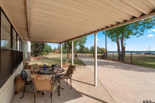 a view of a patio with table and chairs next to a yard