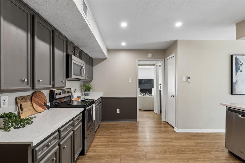 4962 Thunder Road Dallas, TX 75244 - Photo 8 of 26 Kitchen has a walk-in pantry and opens to the powder bath, wet bar and living room beyond.