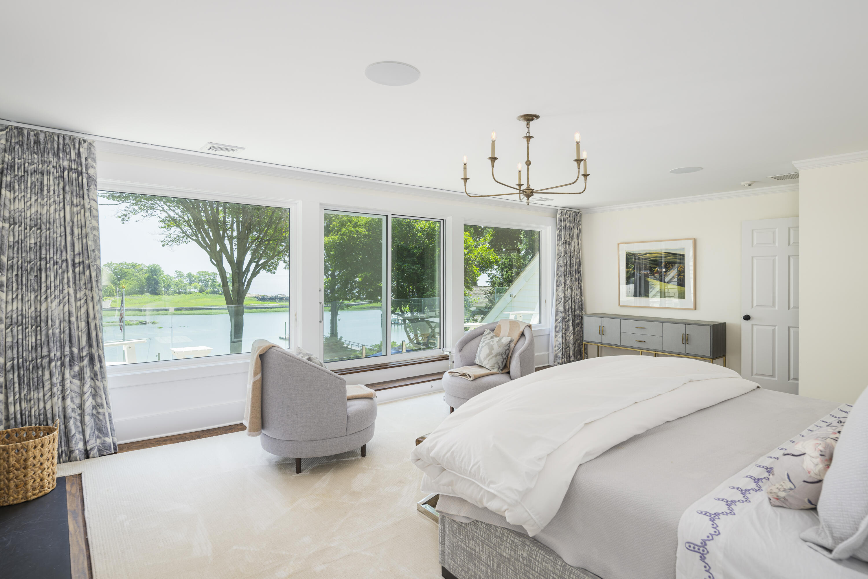123 Long Neck Point Road Darien, CT 06820 - Photo 21 of 40 a bedroom with a bed and large windows