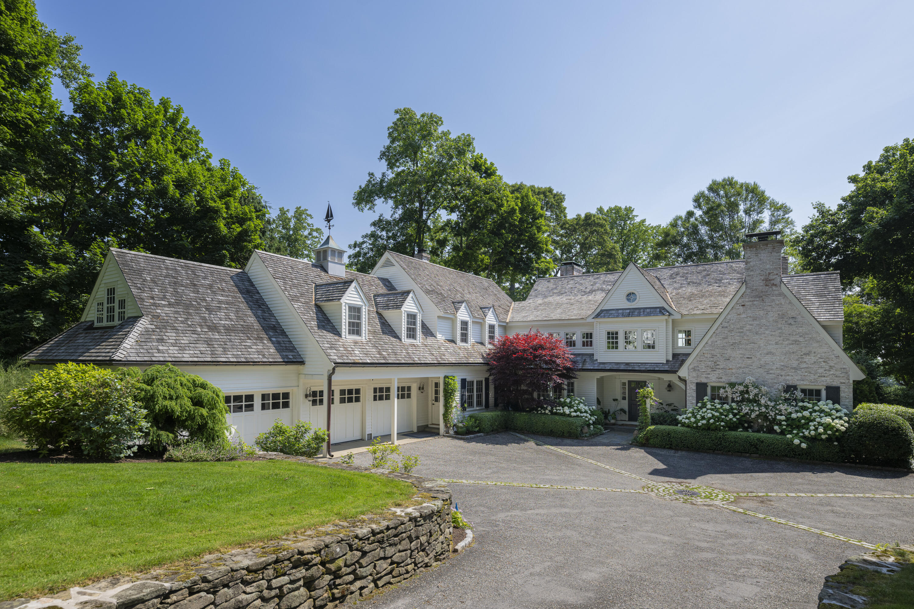 123 Long Neck Point Road Darien, CT 06820 - Photo 3 of 40 a front view of a house with a garden