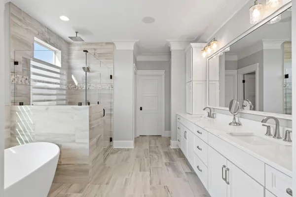 a bathroom with a double vanity sink toilet mirror and bathtub