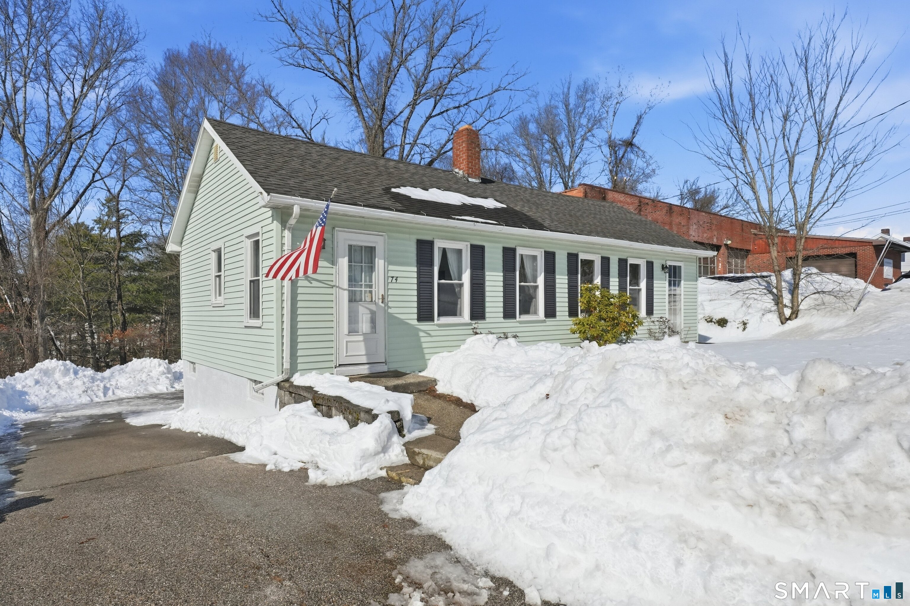 a view of a white house with a yard covered in snow