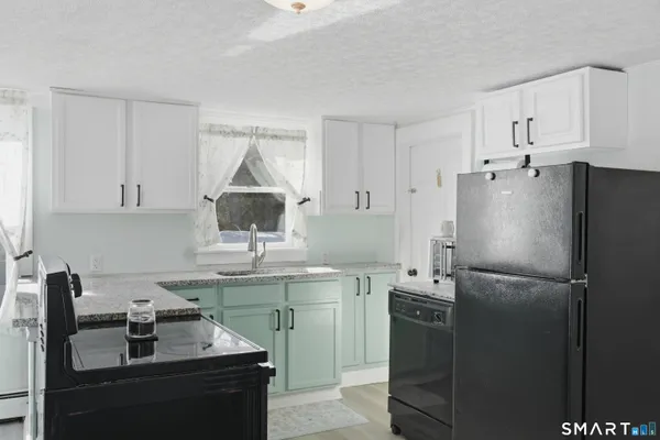 a kitchen with stainless steel appliances granite countertop a refrigerator a sink a stove and island