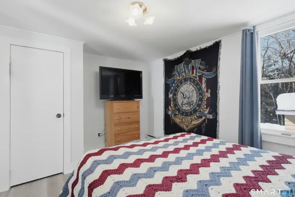 a bedroom with a bed and a flat screen tv