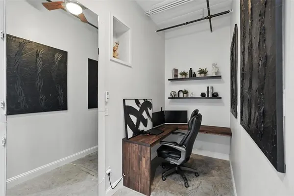 a view of a workspace with furniture and a window