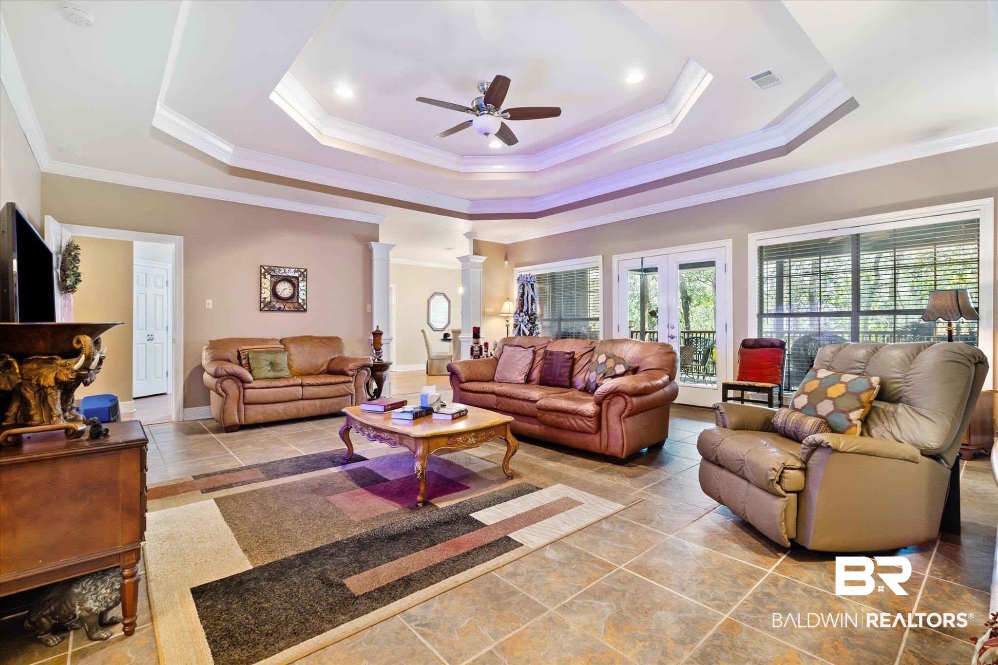 2400 Waterford Road Semmes, AL 36575 - Photo 6 of 30 Living room featuring ceiling fan, ornate columns, a tray ceiling, crown molding, and french doors