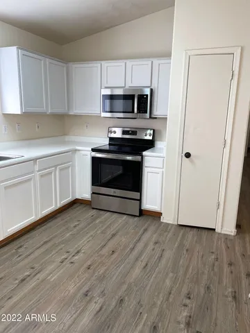 a kitchen with wooden floors and appliances