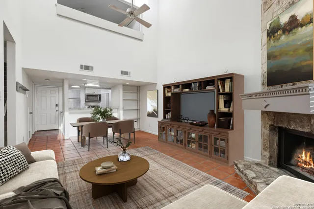 a living room with furniture a flat screen tv and a fireplace