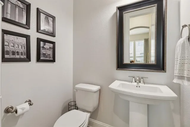 a bathroom with a toilet a sink and mirror