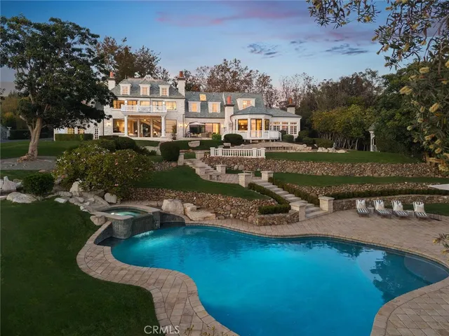 an aerial view of a house with swimming pool a yard and lake view