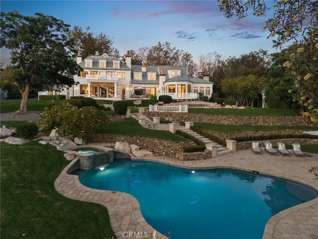 a view of a swimming pool with lawn chairs under an umbrella