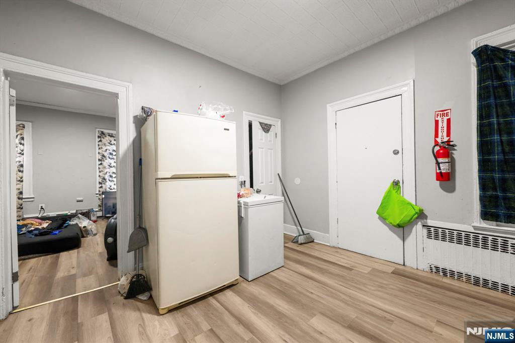 282 Hamilton Avenue Paterson, NJ 07501 - Photo 15 of 21 a kitchen with stainless steel appliances a refrigerator and a wooden floor