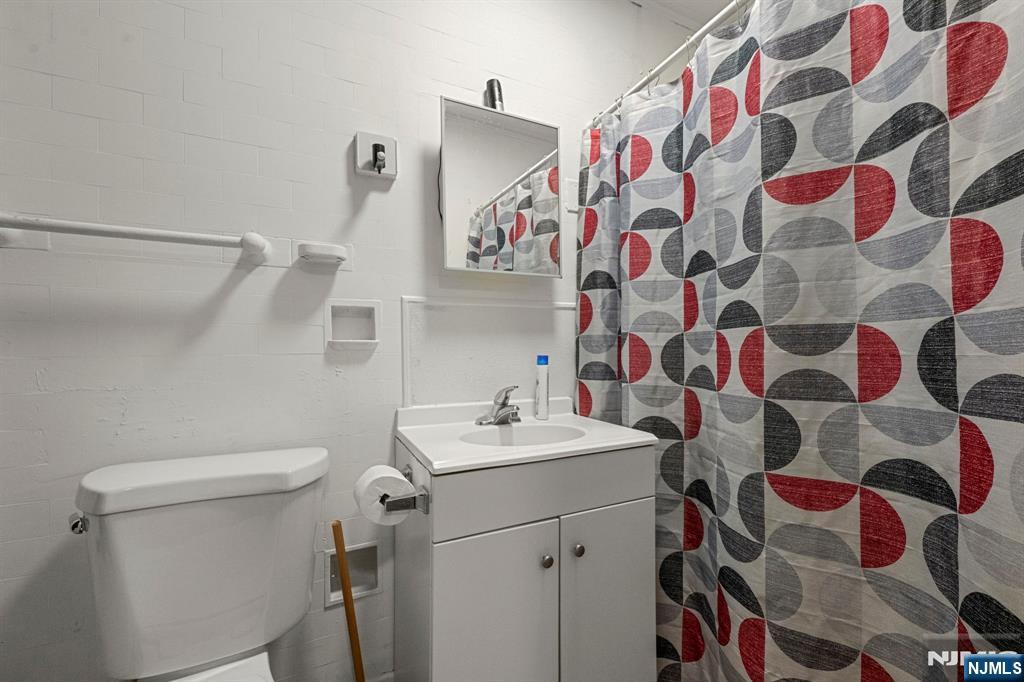 282 Hamilton Avenue Paterson, NJ 07501 - Photo 17 of 21 a bathroom with a sink and mirror with toilet