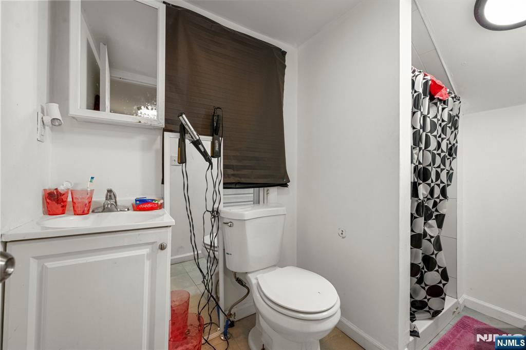 282 Hamilton Avenue Paterson, NJ 07501 - Photo 21 of 21 a bathroom with a toilet and a shower curtain