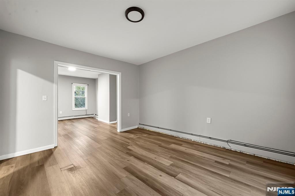 282 Hamilton Avenue Paterson, NJ 07501 - Photo 4 of 21 an empty room with wooden floor and windows
