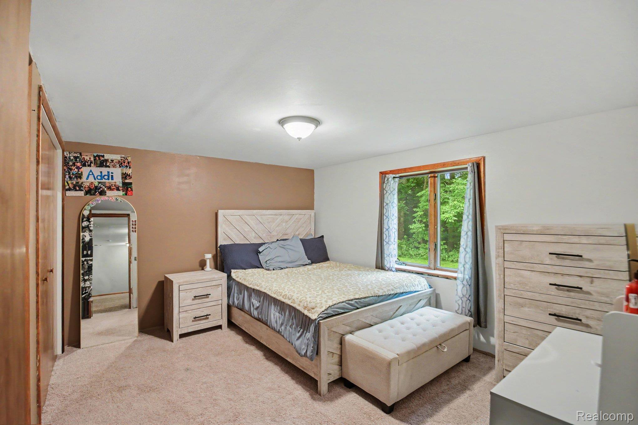 1646 Boy Scout Road Caro, MI 48723 - Photo 13 of 28 Bedroom featuring carpet flooring, a natural wood window frame, and a neutral color palette