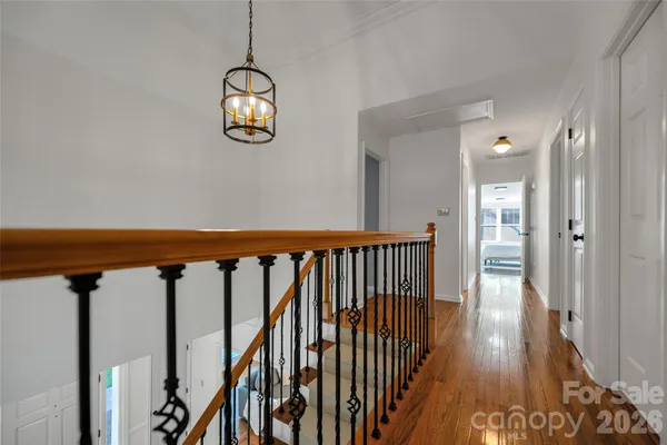 a view of a hallway with wooden floor and stairs
