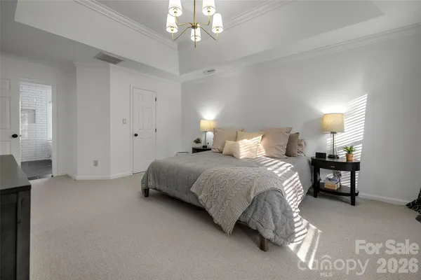 a bedroom with bed and a chandelier
