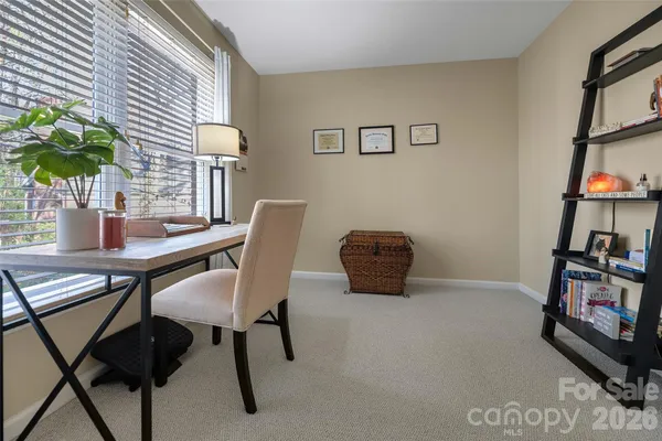 a view of a workspace with furniture and a window