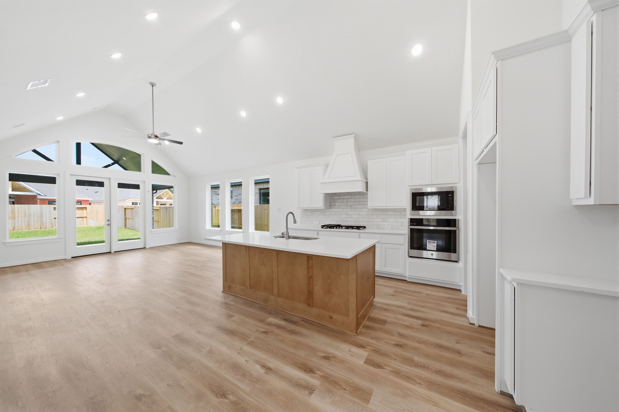 21952 Rolling Grns Road Porter, TX 77365 - Photo 6 of 43 Bright, open-concept kitchen and living area featuring a cathedral ceiling, abundant natural light, and a spacious center island.