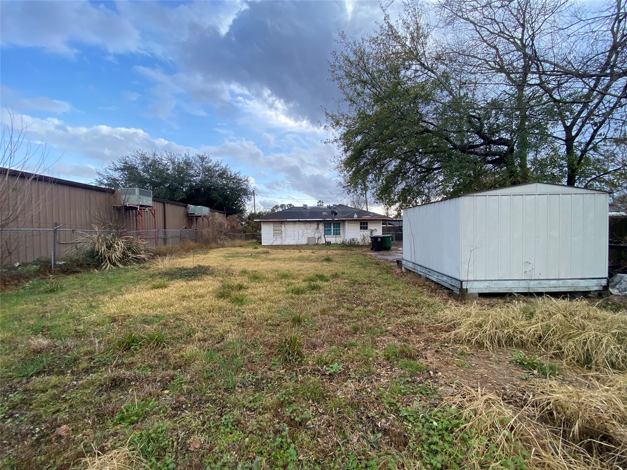 521 East Witcher Lane Houston, TX 77076 - Photo 2 of 5 a backyard of a house with large trees and barbeque oven